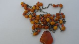 A VINTAGE CORAL AND AMBER SILVER MUFF CHAIN TOGETHER WITH AN AMBER PENDANT