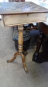 AN ANTIQUE LIFT TOP GAMES TABLE ON TURNED COLUMN SUPPORT AND TRIPOD BASE, THE TABLE HAVING A SLIDE