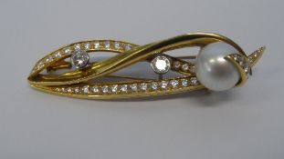 A BOODLE AND DUNTHORPE 18ct YELLOW AND WHITE GOLD RIBBON BROOCH, THE BROOCH SET WITH TWO 25 pts (