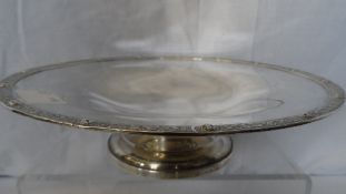 A SOLID SILVER LONDON HALLMARKED FRUIT BOWL ON PEDESTAL FOOT. THE BOWL HAVING SERPENT DECORATION