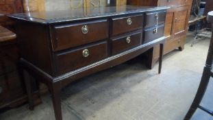 A STAG MAHOGANY EFFECT SIDEBOARD ON TAPERED LEGS - SIX DRAWERS 131 X 47X 72 cms