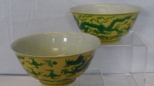 A PAIR OF YELLOW AND GREEN BOWLS PAINTED WITH A LEAPING DRAGON AMONG SCROLLING FOLIAGE AND FLAMING