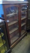 AN EDWARDIAN GLAZED FRONTED DISPLAY CABINET HAVING FOUR SHELVES ENCLOSED, THE FRONT HAVING REEDED