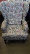 A REPRODUCTION WING BACK ARMCHAIR WITH TAPESTRY UPHOLSTERY.