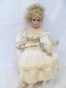 A JANIS HARRIS PORCELAIN DOLL `JESSIE` DATED 1994. THIS CONTEMPORY DOLL IS SEATED ON A WHITE BENCH