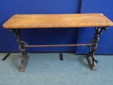 A VINTAGE CAST IRON PUB TABLE DEPICTING A GREEN MAN WITH SINGLE TIE BAR TO CENTRE HAVING A WOODEN