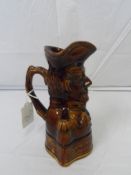 A BROWN POTTERY TREACLE GLAZED WATER JUG DEPICTING THE DUKE OF WELLINGTON, STAMPED THOMPSON,