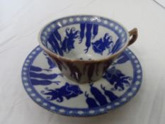 A BLUE AND WHITE BROWN GLAZED TEA CUP AND SAUCER DEPICTING SIAMESE GOLD FISH.