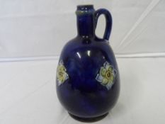 A ROYAL DOULTON ART NOUVEAU STYLE  BLUE CERAMIC SINGLE HANDLED SPIRIT FLASK DEPICTING FLOWERS