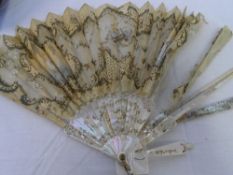A CIRCA 1890 MOTHER OF PEARL AND LACE FAN. THE GUARD STICK INLAID AND DECORATED WITH SILVER AND