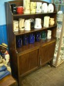 A VICTORIAN MAHOGANY WATERFALL BOOKCASE HAVING THREE OPEN SHELVES TO THE TOP AND CUPBOARDS BELOW