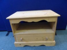 A PINE TELEVISION STAND HAVING AN OPEN SHELF AND A DRAWER BELOW WITH SCALLOPED FRIEZE TO THE TOP,