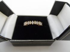 AN 18  CARAT GOLD DIAMOND RING HAVING ELEVEN DIAMONDS, SIX BAGUETTES 4 PTS EACH, 5 BRILLIANTS, 6 PTS