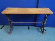 A VINTAGE CAST IRON PUB TABLE DEPICTING A GREEN MAN WITH SINGLE TIE BAR TO CENTRE HAVING A WOODEN