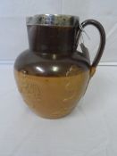 A DOULTON LAMBETH WARE TWO TONE BROWN POTTERY HARVEST JUG WITH BIRMINGHAM HALLMARKED SILVER RIM,