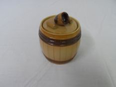 A VICTORIAN TWO TONE BROWN POTTERY TOBACCO JAR IN THE FORM OF A BARREL, THE JAR HAVING A FIGURE OF A