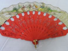 A VICTORIAN SPANISH RED PAINTED IVORY FAN. THE NARROW MOUNT HAVING A LITHOGRAPH FRIEZE DEPICTING A