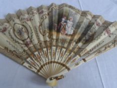 A CIRCA 1900 IVORY FAN DEPICTING LOVERS SEATED. THE MOUNT HAVING APPLIED SEQUINS TO BORDERS. THE