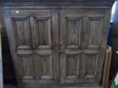A LARGE ANTIQUE PINE STORAGE CUPBOARD, FITTED WITH SHELVES TO THE INTERIOR AND HAVING PANELLED