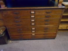 AN EDWARDIAN OAK EIGHT DRAWER TWO PIECE PLAN CHEST HAVING A GREEN LEATHER TOP AND PANELLED SIDES,