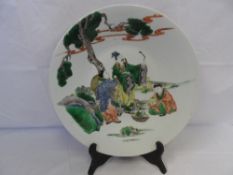 A CHINESE FAMILE ROSE DECORATIVE PLATE DEPICTING THREE FRUIT GROWERS BENEATH A PRUNUS TREE,