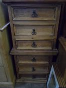 A PAIR OF RECLAIMED PINE BEDSIDE CABINETS ON PLINTH BASES, EACH HAVING THREE DRAWERS - APPROX. 43