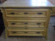 A RECLAIMED PINE CHEST OF DRAWERS HAVING THREE DRAWERS ON CARVED FEET, HAVING A SHAPED TOP WITH