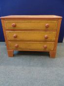 A SMALL INLAID WOODEN CHEST HAVING THREE GRADUATED DRAWERS ON BRACKET FEET AND HAVING FLORAL