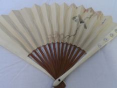 A CIRCA 20TH CENTURY JAPANESE HAND PAINTED IVORY AND PAPER FAN. THE MOUNT DEPICTING A BIRD WITH