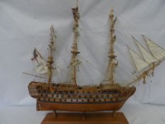A WOODEN MODEL OF A GALLEON ON A STAND, APPROX. 76 X 81 CM
