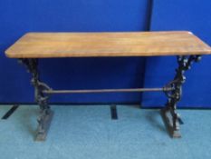 A VINTAGE CAST IRON PUB TABLE DEPICTING A GREEN MAN WITH SINGLE TIE BAR TO CENTRE HAVING A WOODEN