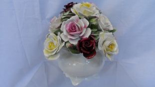 A ROYAL DOULTON ROSE BOWL FULL OF HAND CRAFTED ROSES, THE BOWL BEING IN WHITE, THE FLOWERS IN