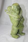 AN INTERESTING CARVED APPLE GREEN STONE NATIVE FIGURE DEPICTING AN ESKIMO WITH PAPOOSE (POSSIBLY