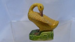 A CIRCA 19th CENTURY CHINESE MODEL OF A SWAN, REALISTICALLY MODELLED IN YELLOW, STANDING ON A SHAPED