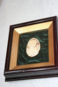 AN OVAL CAMEO DEPICTING A LADY IN A FRAMED AND GLAZED MOUNT, APPROX. 16 X 18 CM