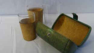 A VINTAGE LEATHER CASED GLASS SET HAVING CORK SURROUNDS.