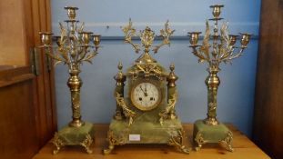 A FRENCH GREEN MARBLE CLOCK GARNITURE, THE CLOCK HAVING BRASS FLORAL SWAGS ON BRASS FEET WITH