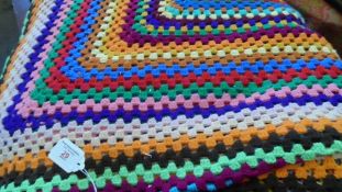 A HAND CROCHET MULTI COLOURED BLANKET