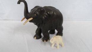 AN ANTIQUE EBONY AND IVORY CARVED ELEPHANT APPROX. 21 X 18 CM TOGETHER WITH A STONE CARVED ELEPHANT