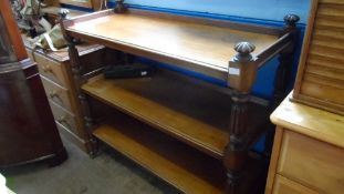 A VICTORIAN MAHOGANY THREE TIER BUFFET HAVING CARVED REEDED SUPPORTS AND FINIALS ON CASTORS, APPROX.