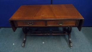 A MAHOGANY EFFECT DROP LEAF OCCASIONAL TABLE ON LYRE SUPPORTS, SPLAYED FEET AND CASTORS