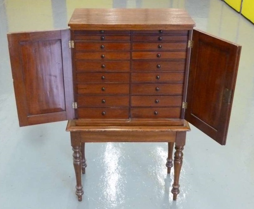 Mahogany stationery cupboard eighteen drawers with hinged doors on a removable base