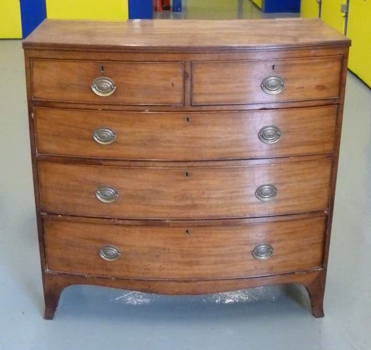 A Georgian mahogany bow front chest of drawers with brass handles on four bracket feet