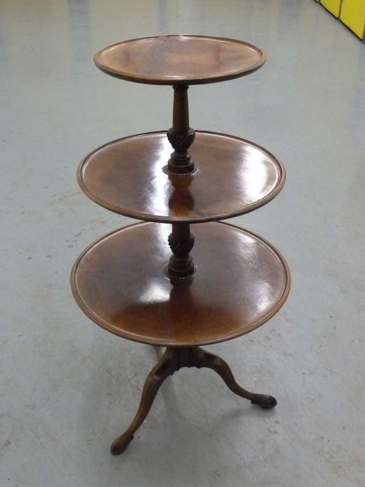 A Victorian mahogany three tier circular server on tripod base.