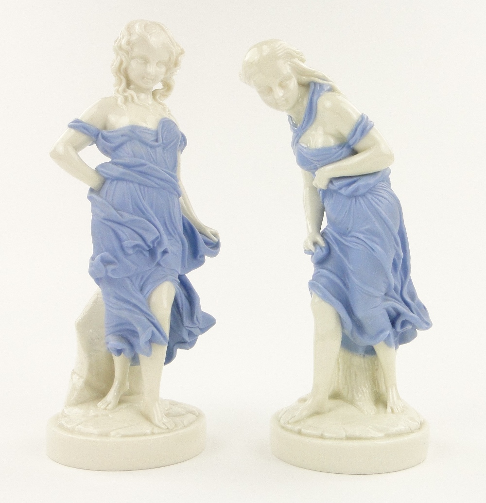 A pair of Worcester figures of girls wearing blue dresses on circular plinths, height 11.25".