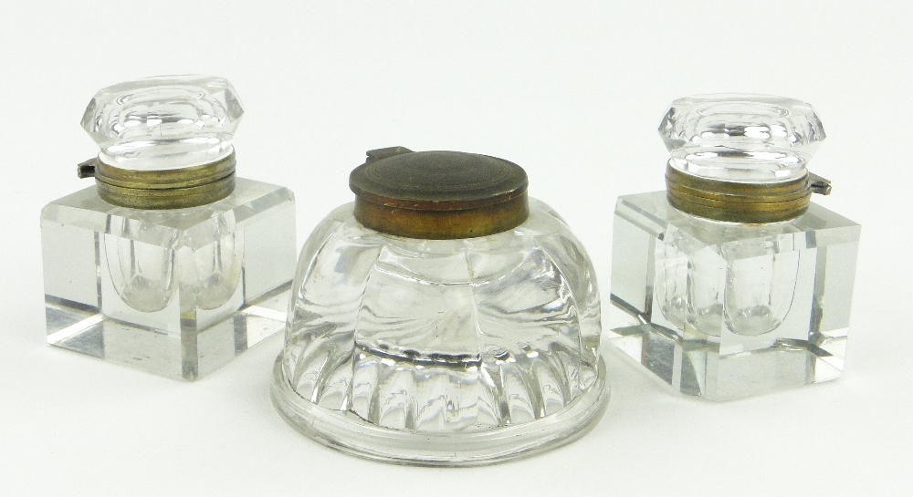 A pair of large cut-glass ink wells and a brass top round moulded brass ink well, height 3".