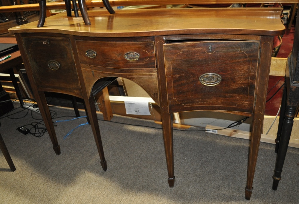 A Georgian mahogany serpentine front sideboard of small size, with central drawer raised on square