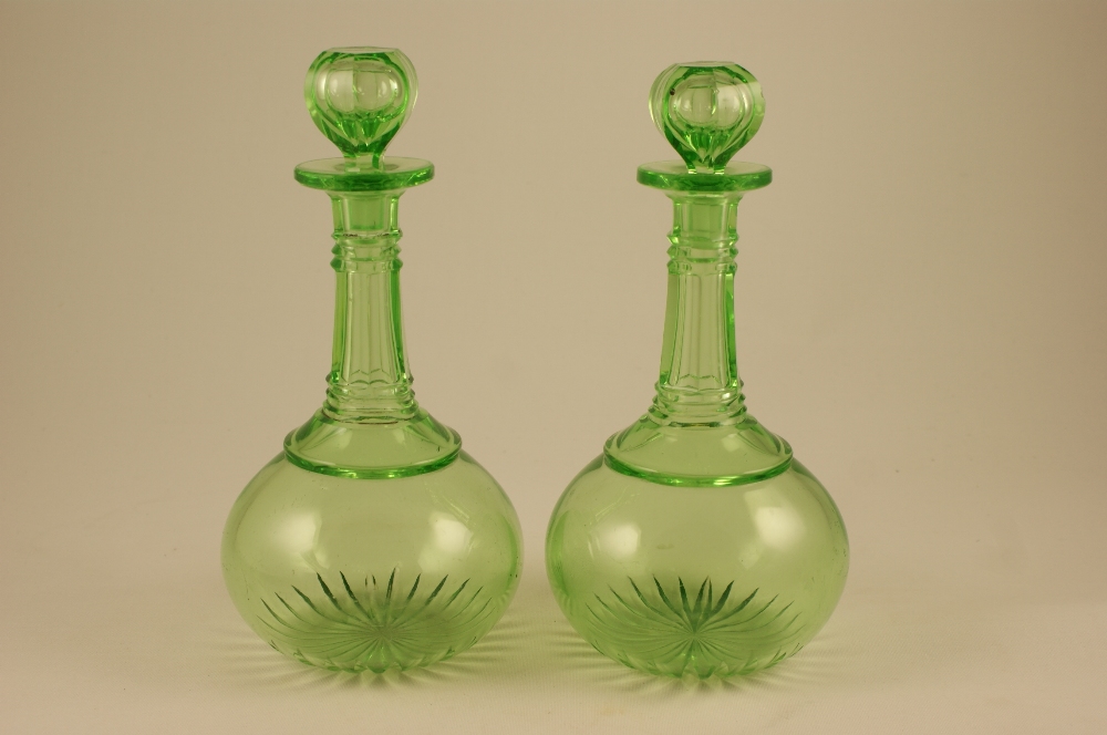 Pair of lime green glass bottle onion form decanters, with faceted necks and stoppers, 28.5cm