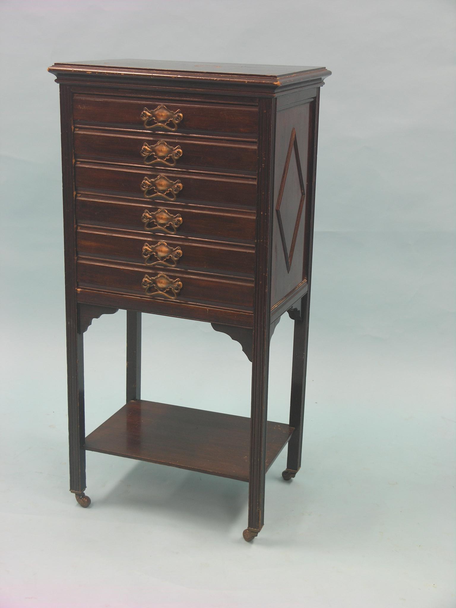 An early 20th century mahogany music chest, six fall-front drawers, on casters, 1ft. 8in.