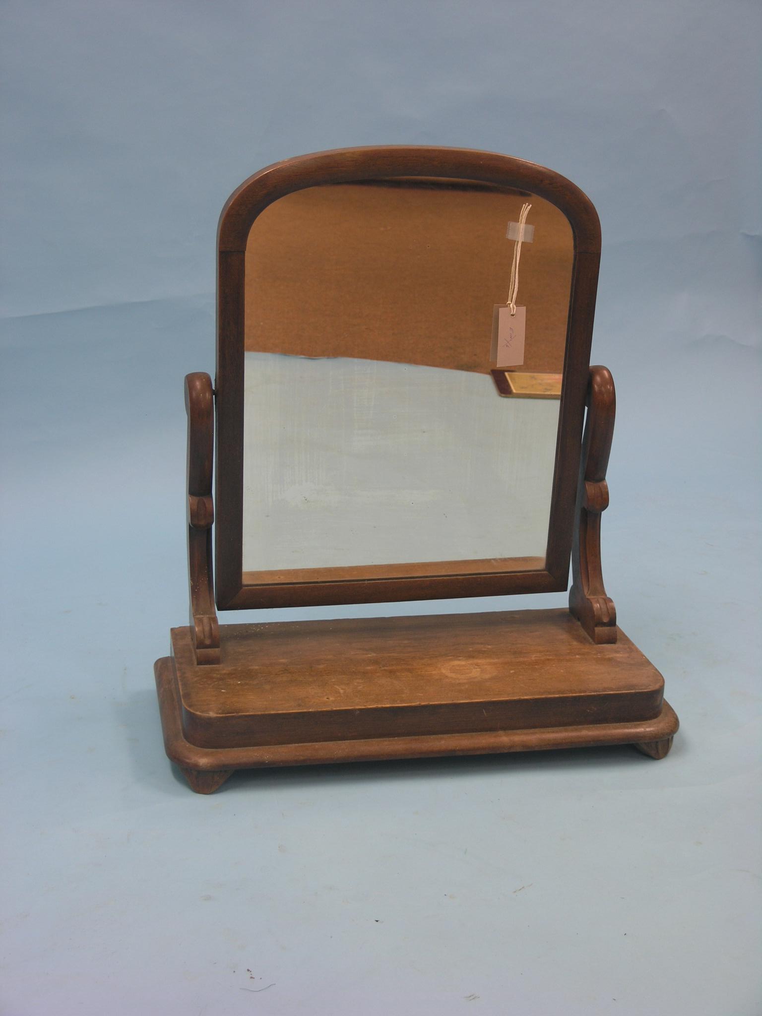 A Victorian mahogany toilet mirror, adjustable on scroll supports, mirror 1ft. 10in. high